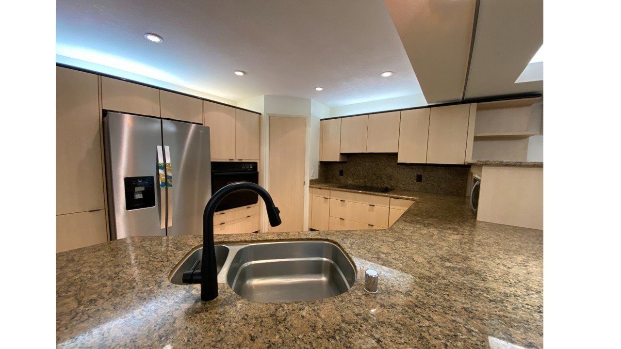 A kitchen with granite countertops and a stainless steel sink.